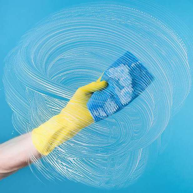 arm of a person cleaning water spots from glass